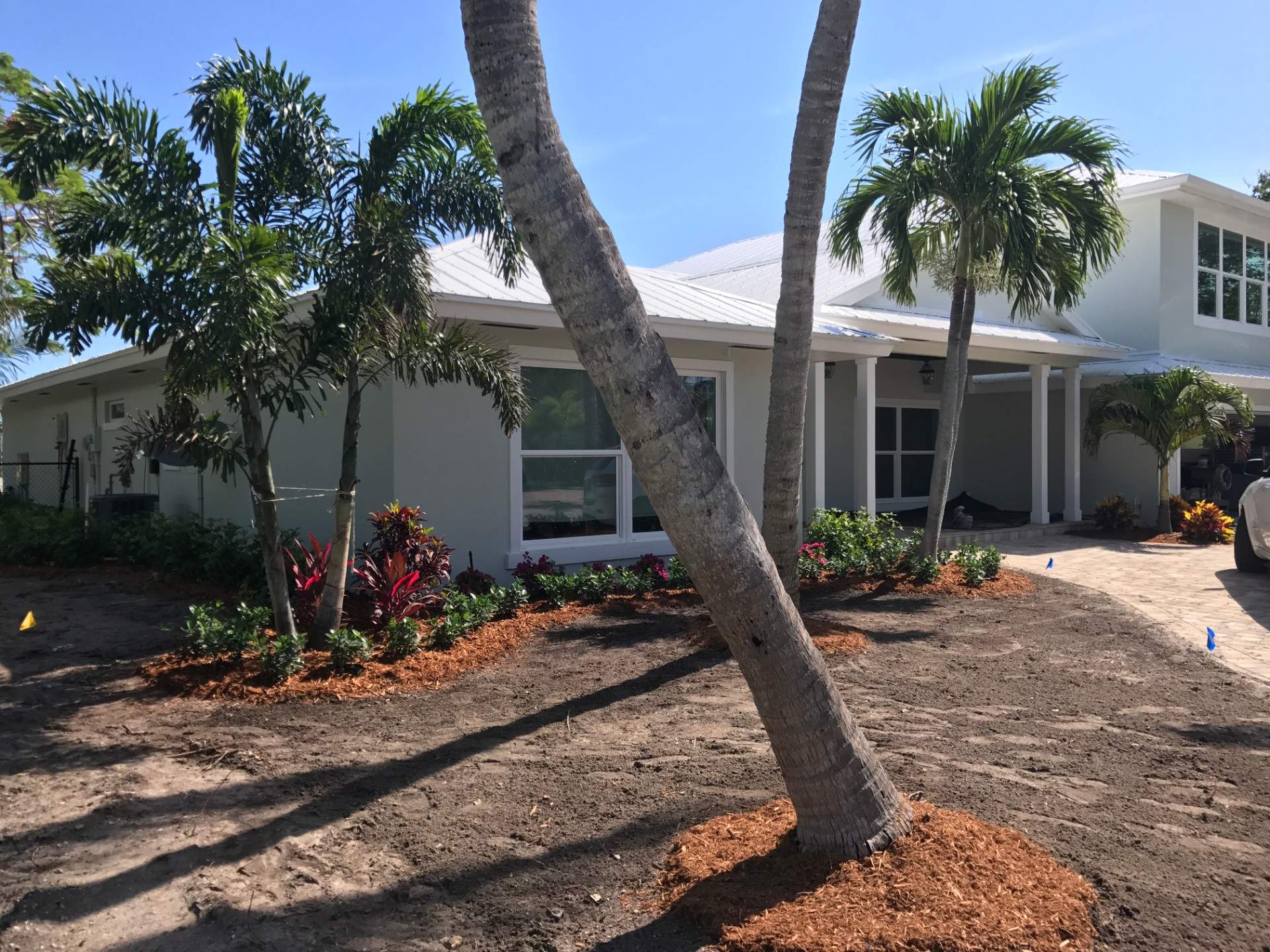 House view from the front, with trees and flowerss